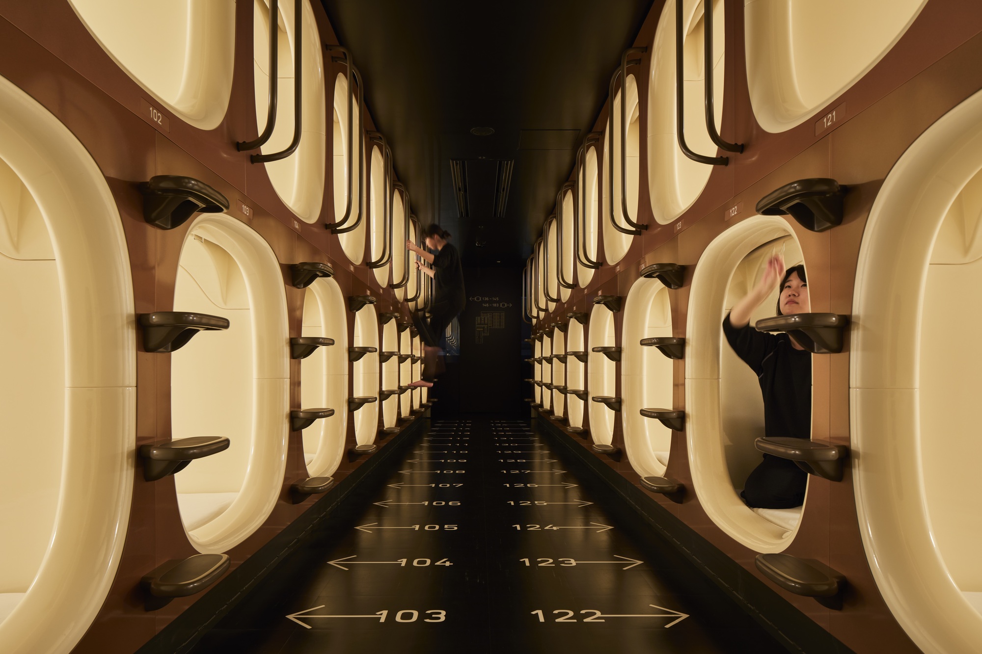 White moulded sleeping pods stacked in two rows at 9h nine hours in Kyoto